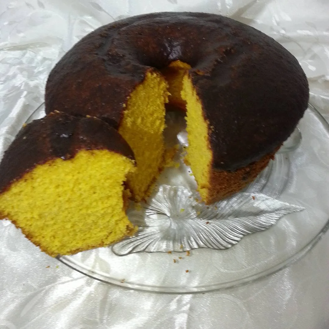 Bolo de cenoura com cobertura de chocolate e uma fatia servida