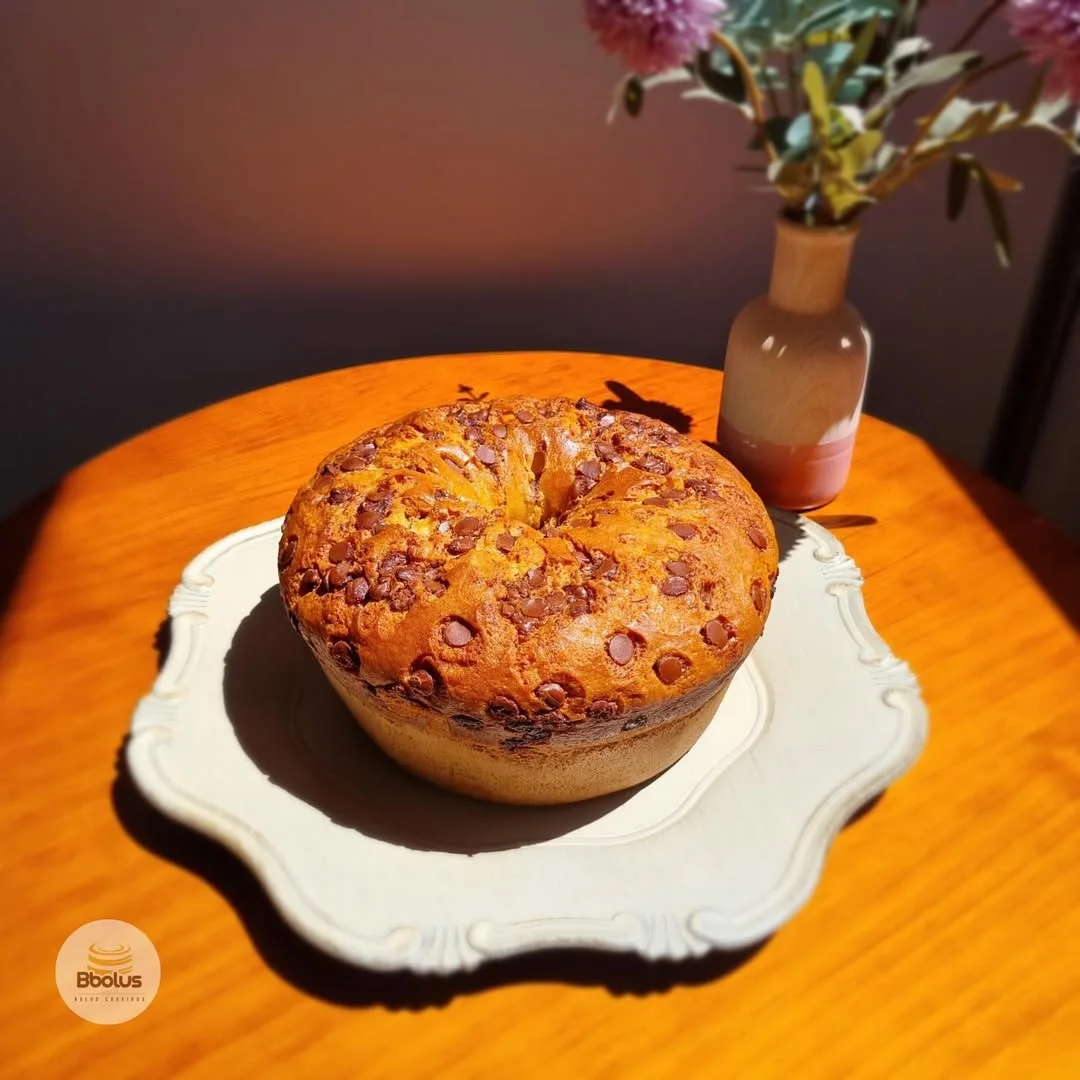 Bolo com gotas de chocolate sobre mesa de madeira